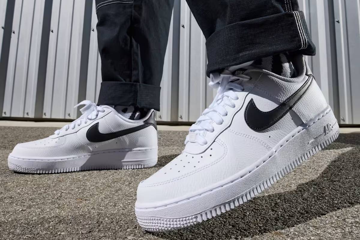 Мъжки бели кожени маратонки Nike Air Force 1 Low с черно лого и бели връзки, заснета в близък план.