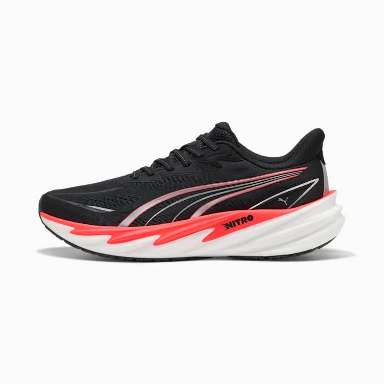 Лява спортна обувка Puma Velocity Nitro 5 в черен цвят, заснета странично от външната страна на бял фон. Моделът разполага с дишаща черна мрежеста горна част, сребристи контури на емблемата Puma Formstrip и бяла амортизираща подметка с ярък червено-оранжев акцент и надпис NITRO.